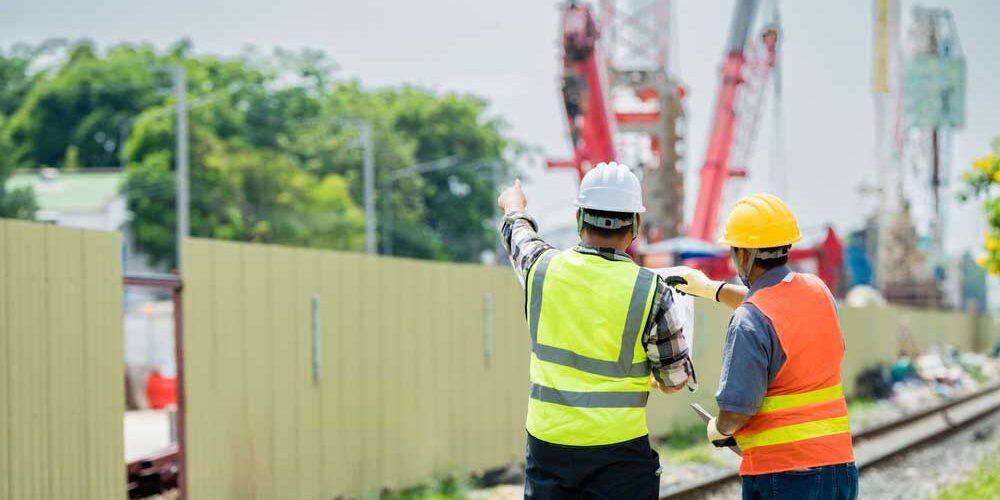 group of technicians in reflective vests discussing sewer project plans