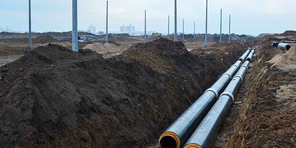 Laying underground storm sewers at a construction site. Groundwater system for new residential buildings in the city. Installation of water main, sanitary sewer, storm drain systems in city.